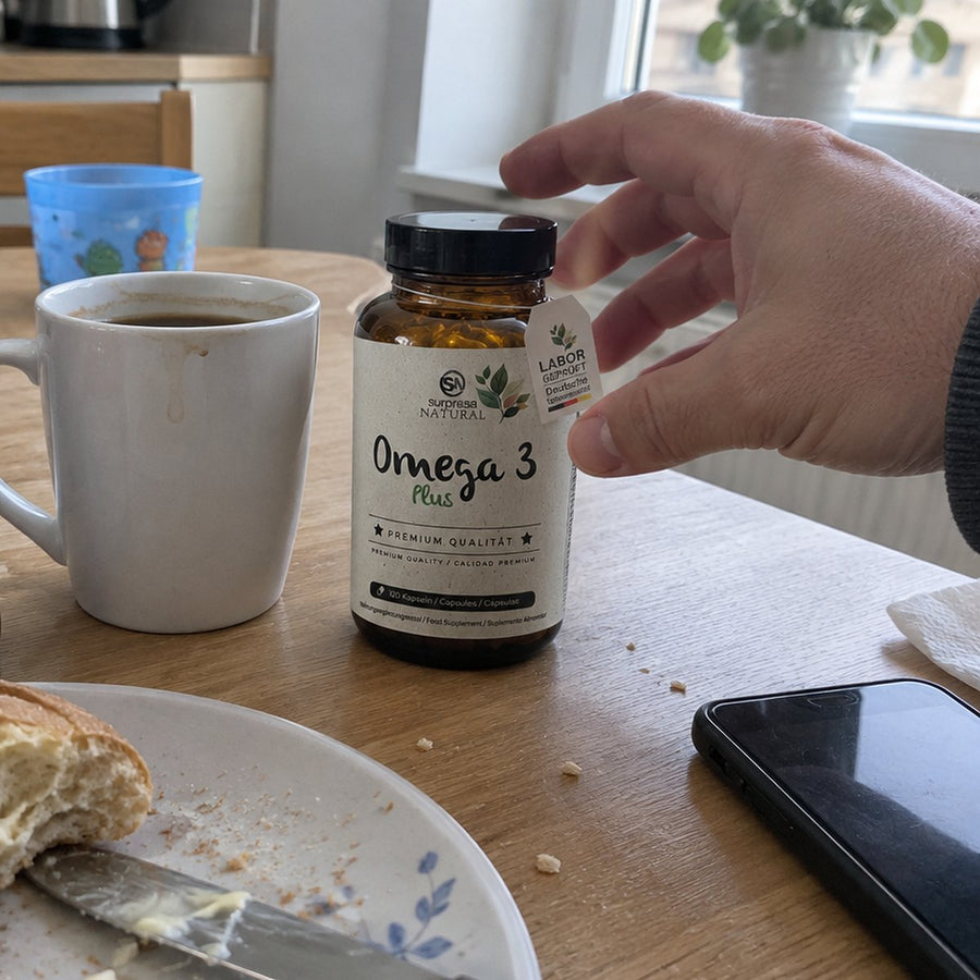 Frühstückstisch, eine Hand greift nach Surpresa Natural Omega 3 Plus
